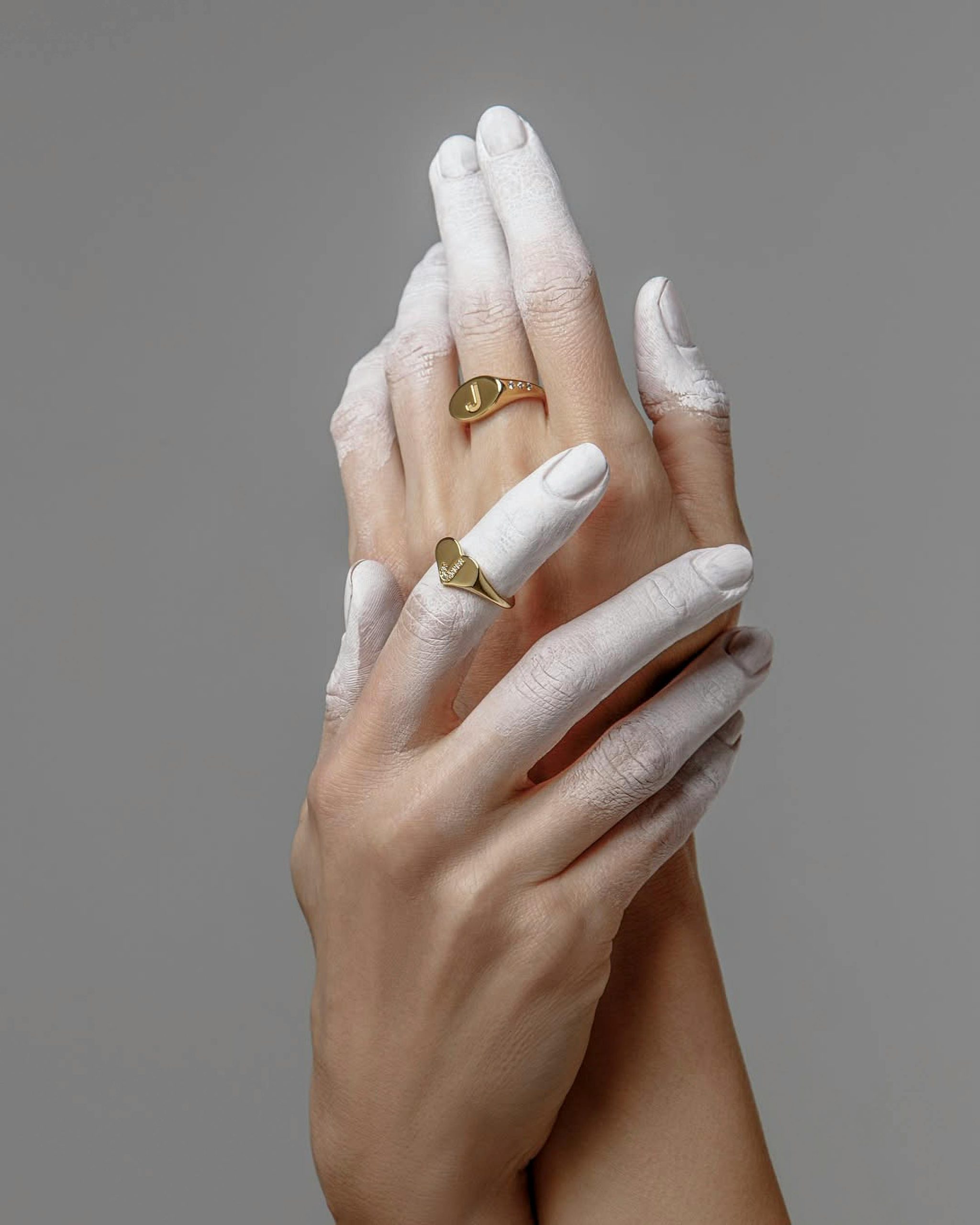 Hands with white almond nails and gold rings