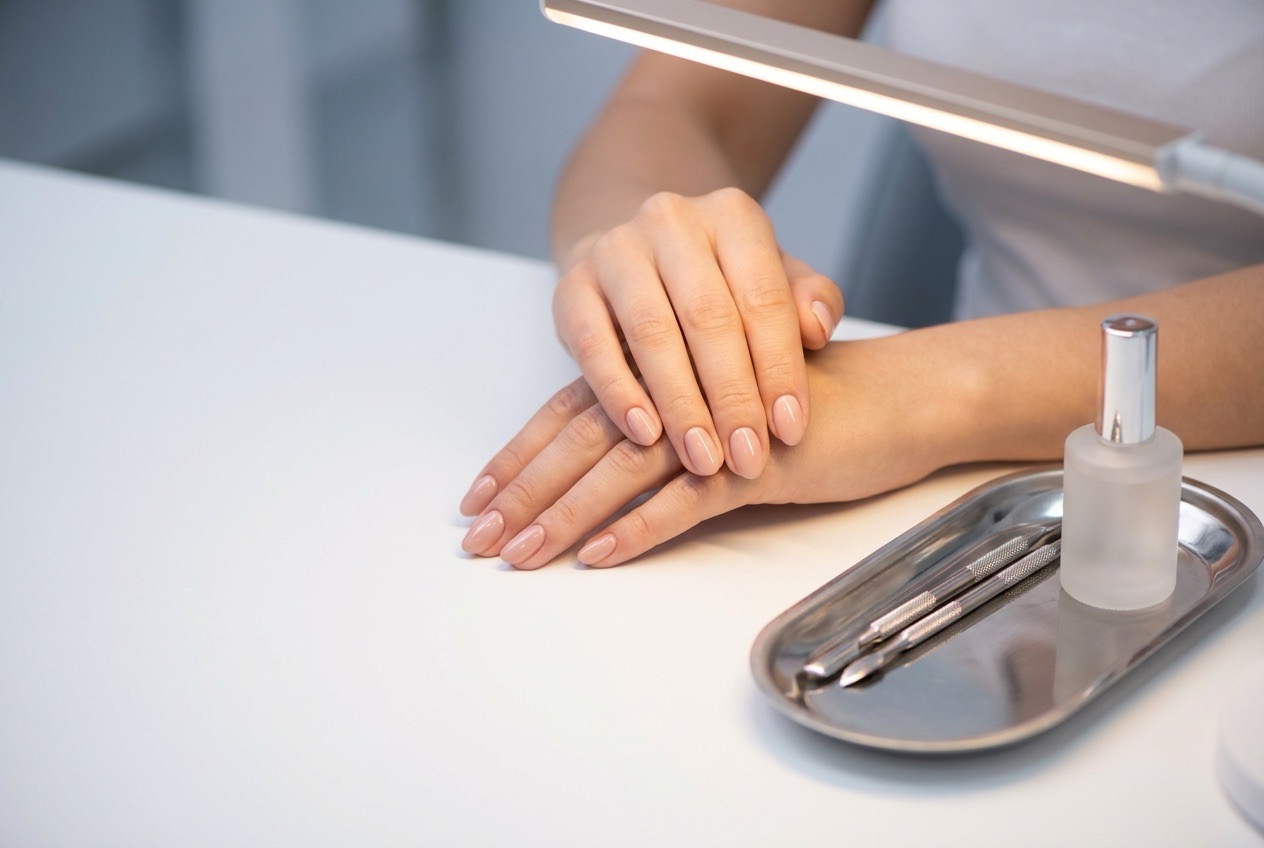 Client hands on a clean workstation with a steel instrument tray under a lamp